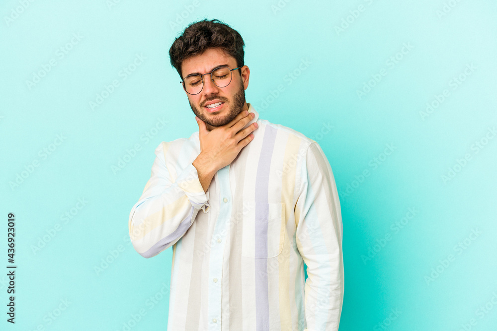 Young caucasian man isolated on blue background suffers pain in throat due a virus or infection. Young caucasian man isolated on blue background suffers pain in throat due a virus or infection.