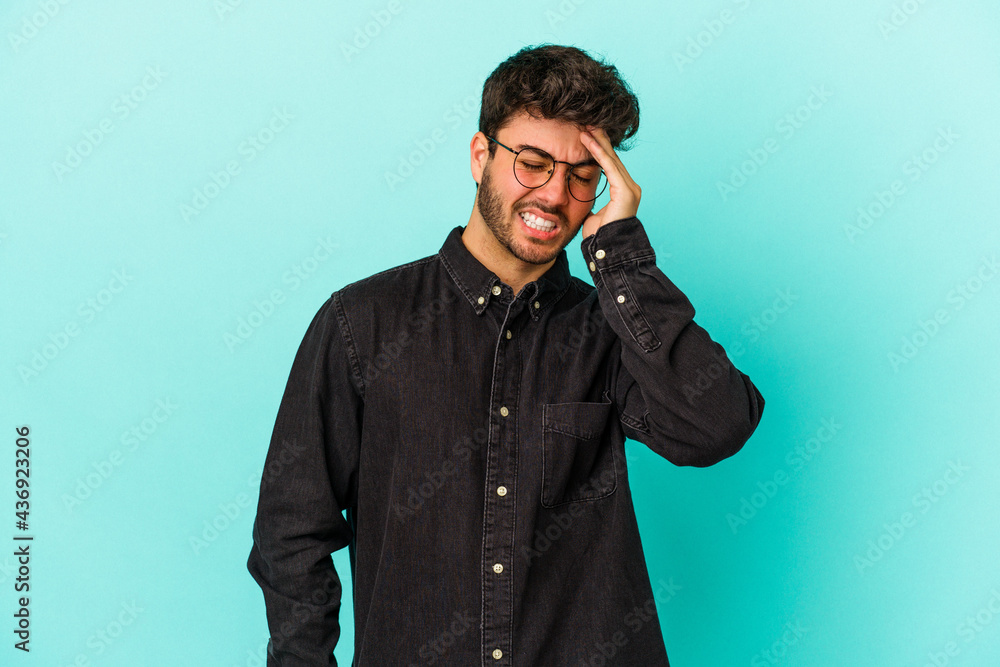 Young caucasian man isolated on blue background forgetting something, slapping forehead with palm and closing eyes. Young caucasian man isolated on blue background forgetting something, slapping forehead with palm and closing eyes.