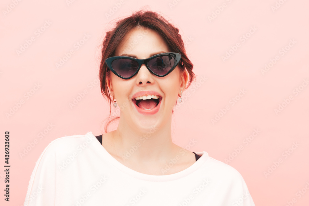 Young beautiful smiling female in trendy summer hipster clothes. Sexy carefree woman posing near pink wall in studio. Positive model having fun indoors.Cheerful and happy Young beautiful smiling female in trendy summer hipster clothes. Sexy carefree woman posing near pink wall in studio. Positive model having fun indoors.Cheerful and happy