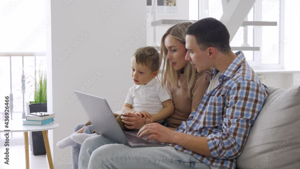 Young smiling happy couple sitting with a boy kid 3-4 years old at home talking on virtual meeting chat video call to grandparents. Leisure happy time together family concept. Young smiling happy couple sitting with a boy kid 3-4 years old at home talking on virtual meeting chat video call to grandparents. Leisure happy time together family concept.