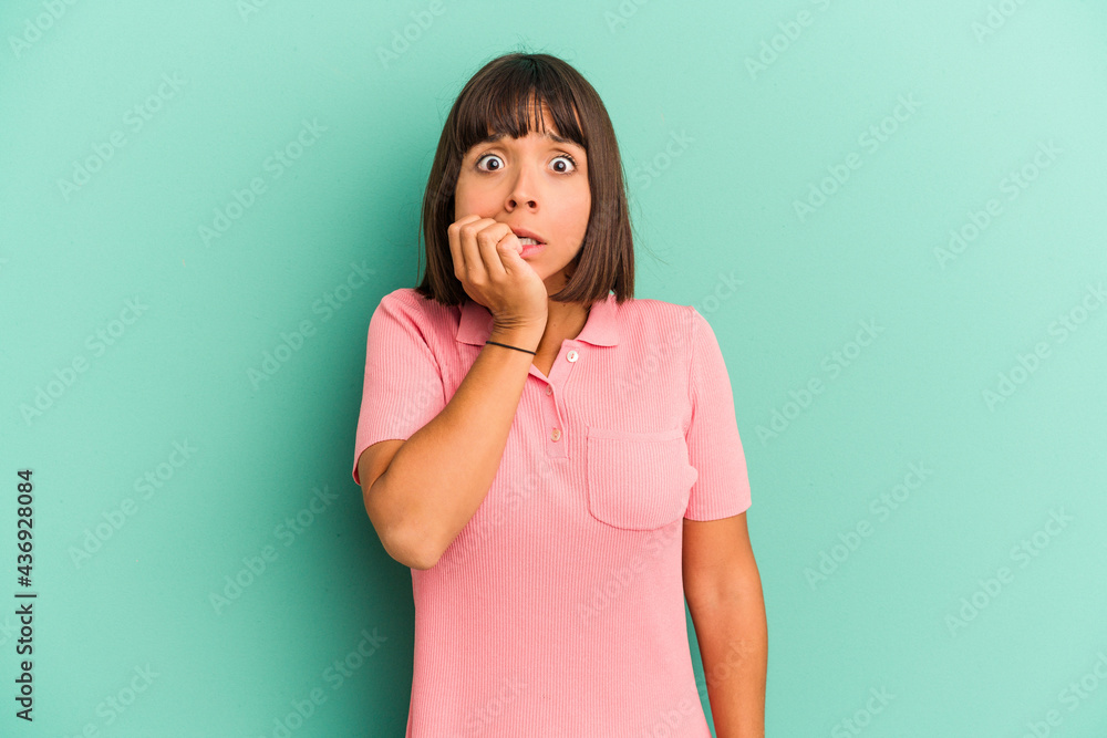 Young mixed race woman isolated on blue background biting fingernails, nervous and very anxious. Young mixed race woman isolated on blue background biting fingernails, nervous and very anxious.