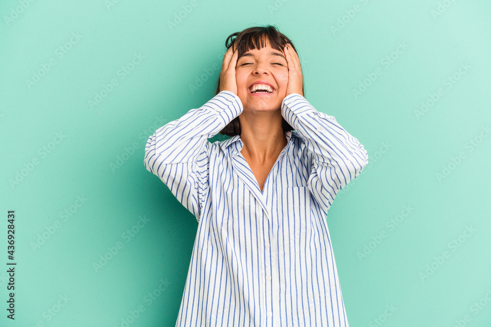 Young mixed race woman isolated on blue background shrugs shoulders and open eyes confused. Young mixed race woman isolated on blue background shrugs shoulders and open eyes confused.