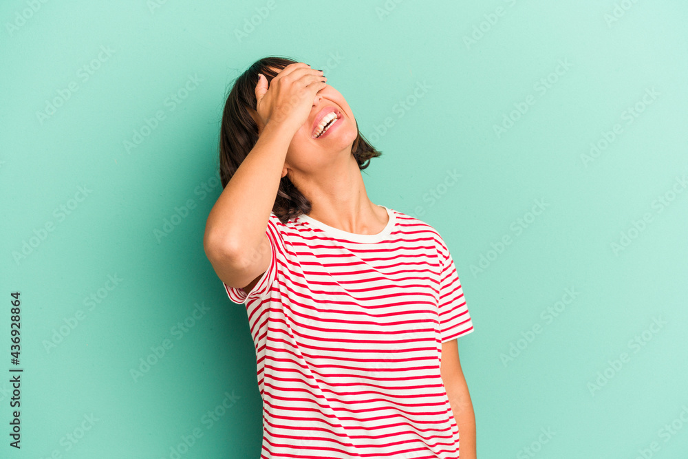 Young mixed race woman isolated on blue background shrugs shoulders and open eyes confused. Young mixed race woman isolated on blue background shrugs shoulders and open eyes confused.