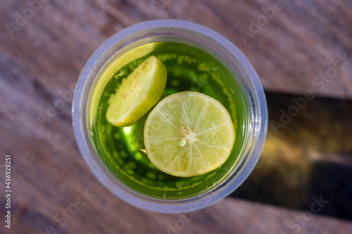 Mojito drink in a plastic cup on wooden table background , top view