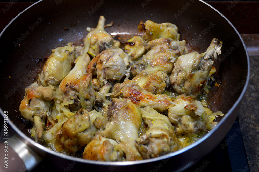 home cooking, fried chicken wings with onions in a pan home cooking, fried chicken wings with onions in a pan