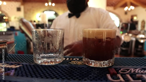 Bartender serving a carajillo coffee alchoholic drink in bar photo