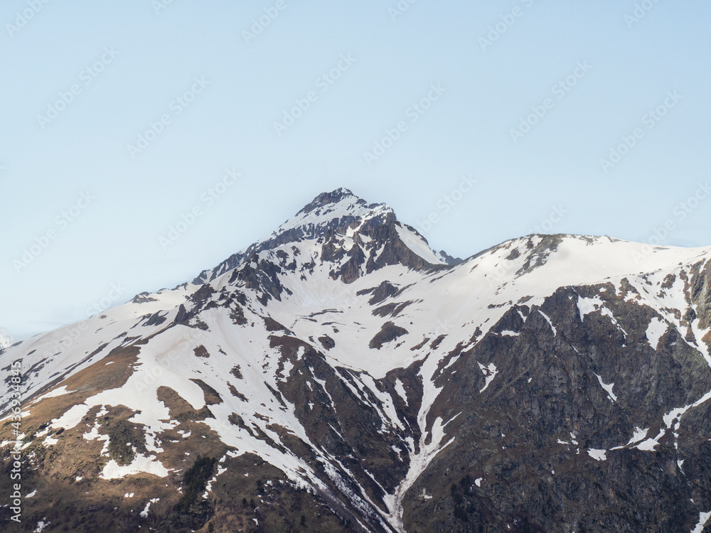 A landscape with a view of a mountain snow-covered peak. Travel, tourism to the Caucasus Mountains, Dombay. The concept of wildlife without a trace of humans.