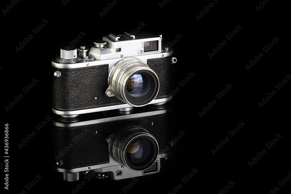 Rare old rangefinder camera, released 50's on black glass background.