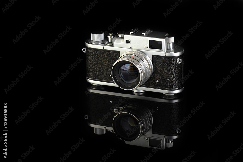 Rare old rangefinder camera, released 50's on black glass background.