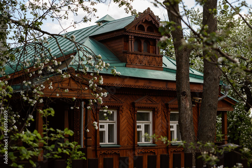 Facade of vintage wooden house with ornamental carved windows. Russian folk style in architecture. © spritnyuk