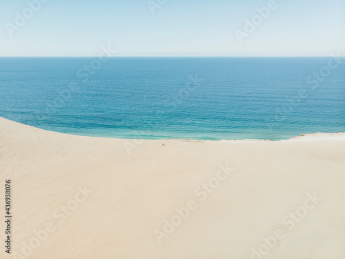 Aerial view of two people standing on Carlo Sandblow and looking down on the ocean, Queensland, Australia. photo