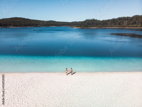 Aerial view of a couple walking down towards the water at Lake McKenzie, Fraser Island, Queensland, Australia.