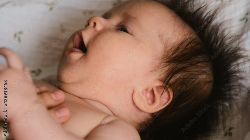 Authentic young mother strokes face newborn baby playing with tenderness and care for the child. Maternity and motherhood concept. Authentic young mother strokes face newborn baby playing with tenderness and care for the child. Maternity and motherhood concept.