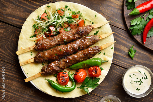 Turkish Adana Kebab with fresh vegetables on flatbread photo