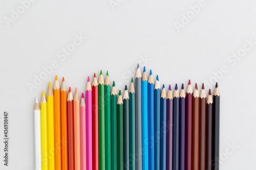 Colored pencils on grey background. Top view with copy space. Flat lay. Back to school concept.