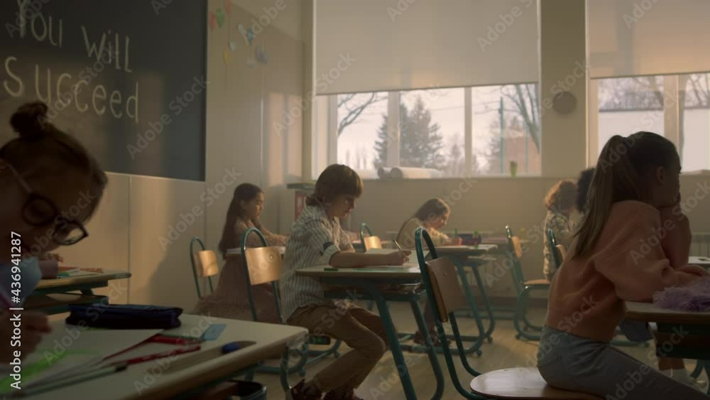 Kids sitting at school desks in classroom. Students preparing for lesson Kids sitting at school desks in classroom. Students preparing for lesson