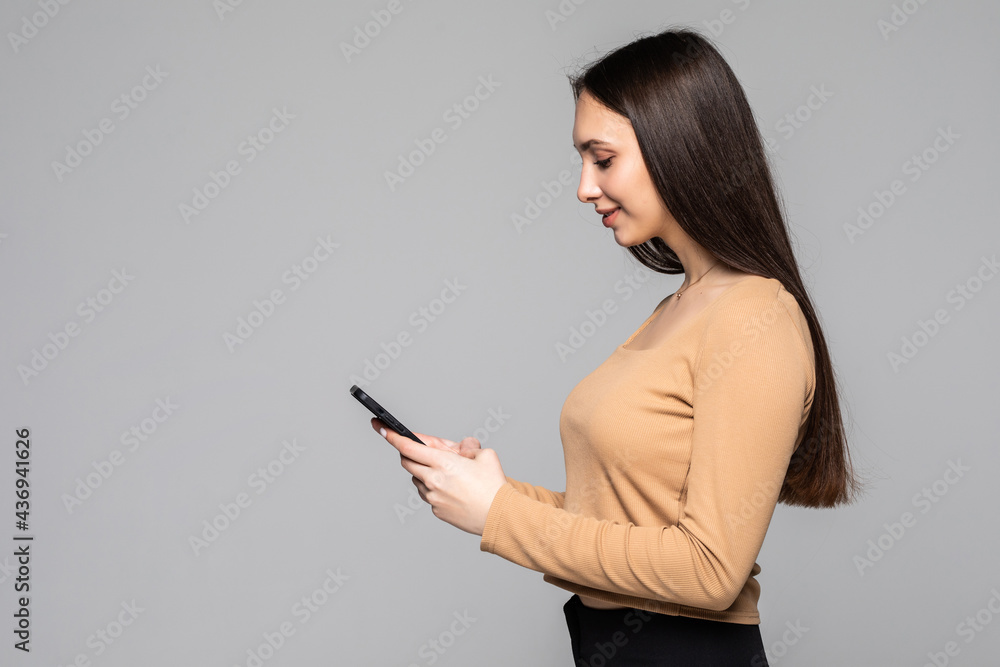 Portrait of woman holding in hands device web surfing copy space isolated over light white gray background Portrait of woman holding in hands device web surfing copy space isolated over light white gray background
