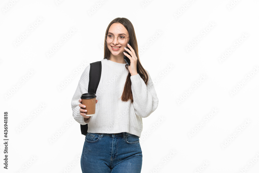 Happy young woman university student with backpack and books talking on cell phone isolated on white background Happy young woman university student with backpack and books talking on cell phone isolated on white background