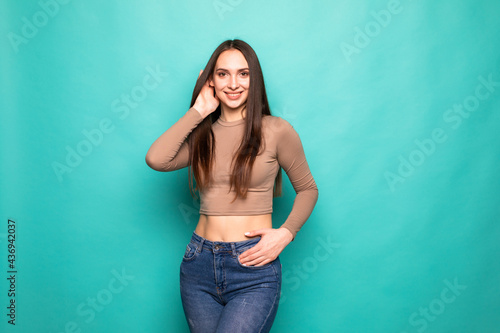 Advertising concept. Portrait of young woman isolated on vivid turquoise background © dianagrytsku