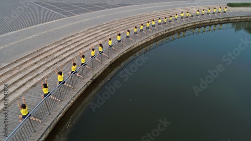 Canvas Print Women practice yoga by the river in the park, aerial photos, North China