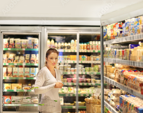 Woman choosing frozen food from a supermarket freezer © lado2016