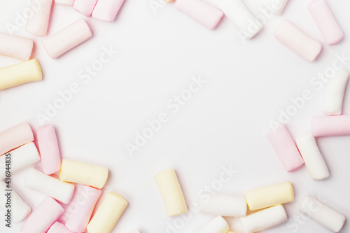 Multicolored marshmallows on a white background with a place for an inscription in the center. Banner for a pastry shop postcard.