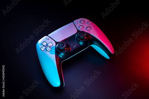Modern white gamepad illuminated in red and blue. Game controller for video games and e-sports on a dark back