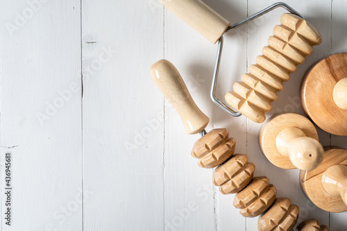 Wood massage maderotherapy madero therapy wooden rolling pin or battledore tools for anti cellulite treatment to stimulate the lymphatic system and improve circulation concept copy space top view photo