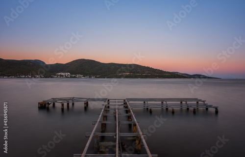 sunset over bay in Aegean sea. Torba, Bodrum, Turkey. October 2020. Long exposure picture with pier, jetty