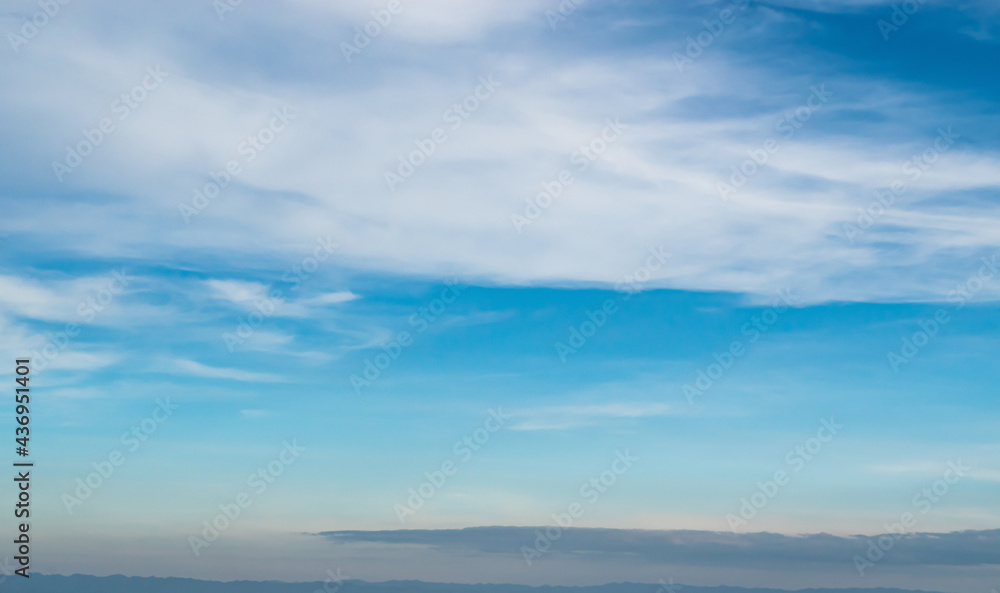 Obraz premium Blue sky against soft white clouds. Beautiful natural cloudscape background.