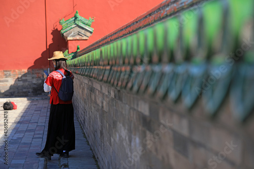 Female tourists play in the classical architecture of the temple of heaven in Beijing