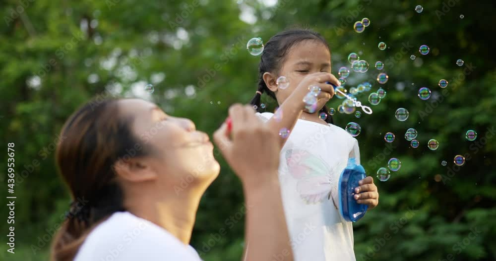 Mom and daughter blowing and catching soap bubbles Mom and daughter blowing and catching soap bubbles