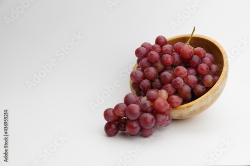 Wallpaper Mural Fresh and ripe red grapes in a wooden bowl, isolated in white background. Bunch of raw and juicy grapevines Torontodigital.ca