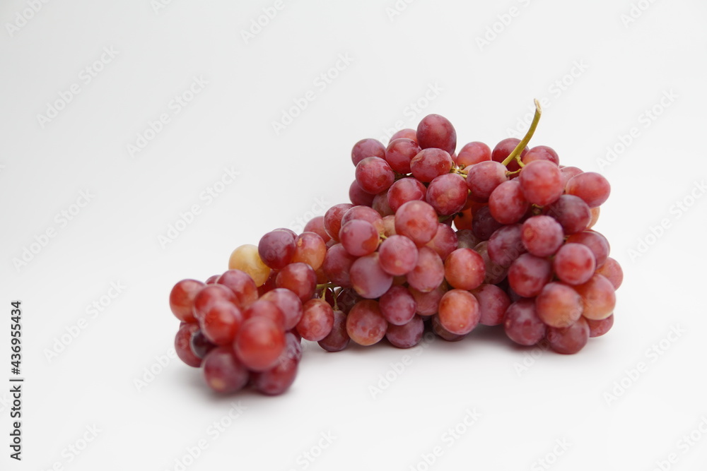 Fresh and ripe red grapes isolated in white background. Bunch of raw and juicy grapevines