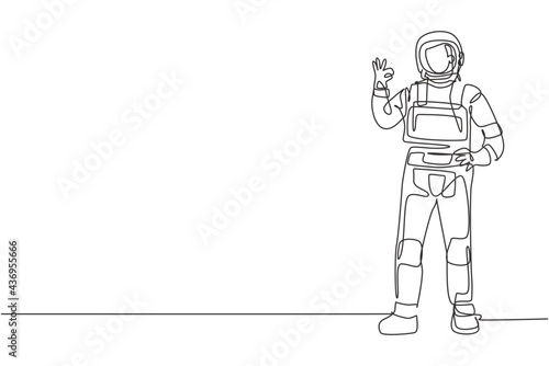 Single continuous line drawing astronaut stands with gesture okay wearing space suit exploring earth, moon, other planets in the universe. Dynamic one line draw graphic design vector illustration