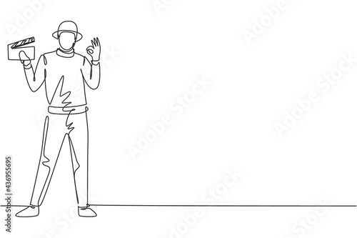 Continuous one line drawing film director stands with gesture okay holding clapperboard and prepare camera crew for shooting at television studio. Single line draw design vector graphic illustration