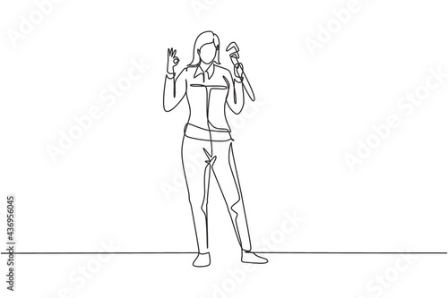 Single continuous line drawing female plumber stands with gesture okay and holding carpentry tool fixing broken plumbing at home. Success business. One line draw graphic design vector illustration