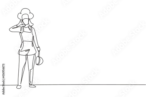 Single one line drawing female chef stands with call me gesture  holding pan and wearing cooking uniform prepares ingredients to cook dishes. Continuous line draw design graphic vector illustration