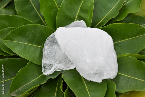 Alum cubes on leaves background, concept for herb, bodycare, skincare, waterclear and protect armpit smell. photo