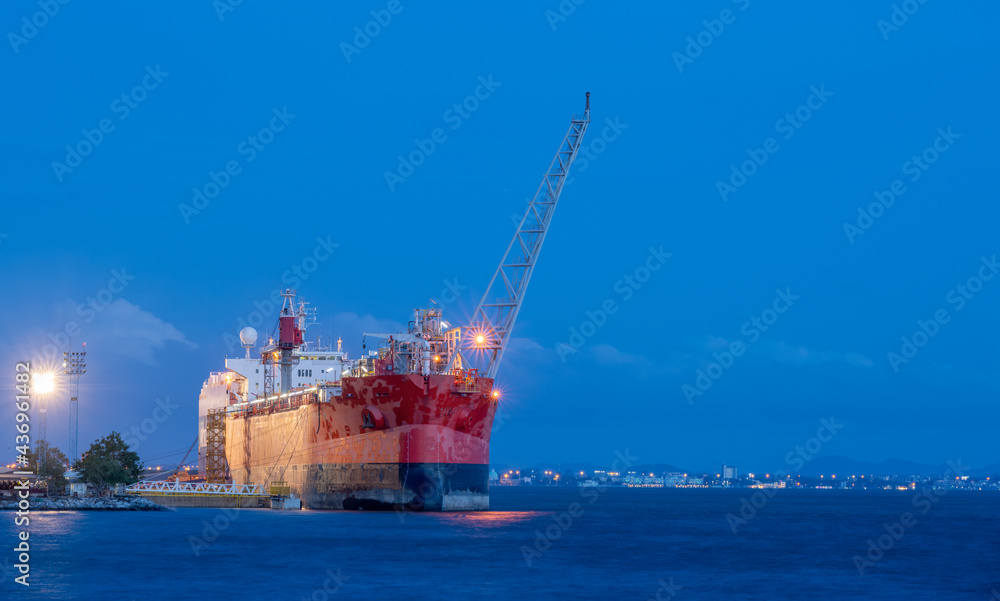 Large cargo commercial ship loading in port terminal ,Logistics and transportation International Cargo ship in the ocean at blue sky background.