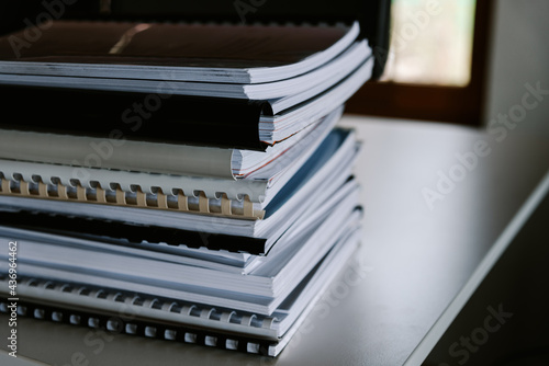 Stack of reports lies on a desk ready for review