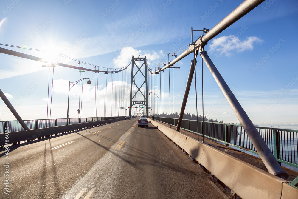 Obraz premium Drive across the famous Lions Gate Bridge in the modern Downtown City. Sunny Winter Day. Vancouver, British Columbia, Canada