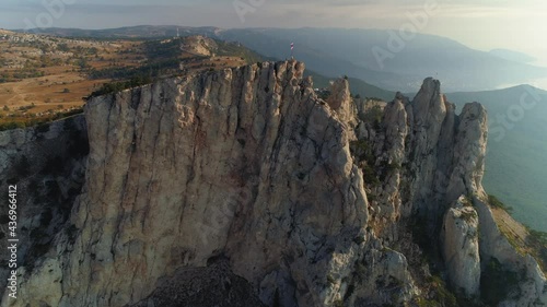 Aerial sideways Ai-Petri Ukrainian Russia epic mountains windiest places in Crimea Alupka travel beautiful attraction at sunrise. Sharp cliffs prongs tops. Weathering of reef limestones geology. Stock photo