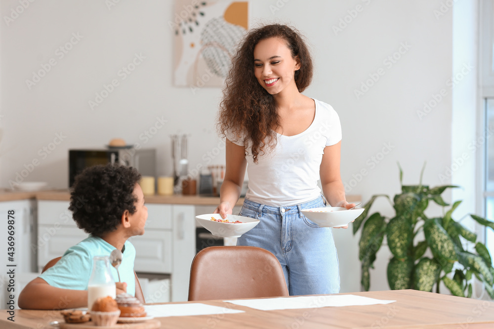 Little boy with mother eating cornflakes at home Little boy with mother eating cornflakes at home
