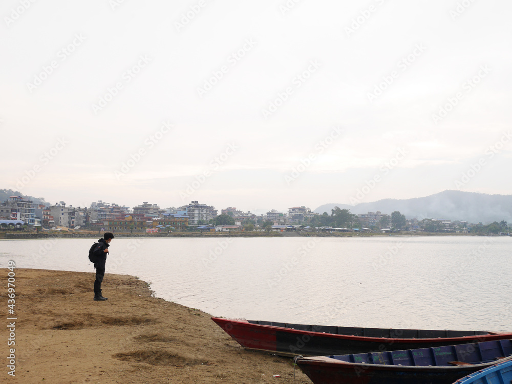 Viewpoint and wooden canoe boat of nepali floating in Phewa Tal or Fewa lake wait service Nepalese people and foreign travelers rowing travel relax visit tour at Pokhara of Gandaki Pradesh in Nepal