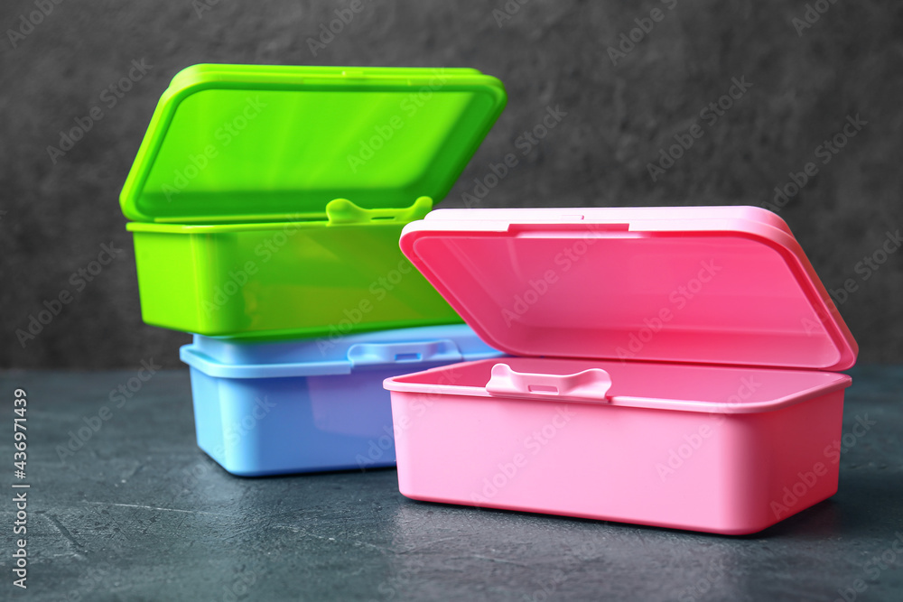 Plastic lunch boxes on dark background Plastic lunch boxes on dark background