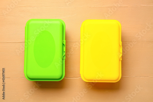 Plastic lunch boxes on color background