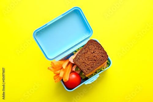 Lunch box with tasty food on color background