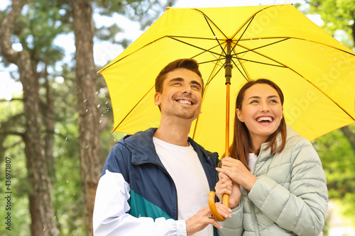 Young couple with umbrella ...