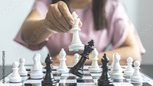 Businesswoman holding chess to take down opposing players, Proactive business planning and marketing strategy just like playing chess, Business competition and success, Leadership concept.